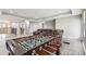 Finished basement with hardwood floors, featuring a foosball table and comfortable seating at 10701 Morning Dew Way, Tampa, FL 33647