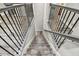 Elegant staircase with wrought iron railing and wood steps, providing a grand transition between floors at 10701 Morning Dew Way, Tampa, FL 33647