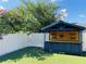 A fully fenced backyard featuring a covered outdoor bar with an attached tv and maintenance-free artificial turf at 12215 Blue Pacific Dr, Riverview, FL 33579