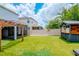 Lovely backyard with artificial turf, wooden pergola, custom bar, and bench seating area at 12215 Blue Pacific Dr, Riverview, FL 33579