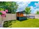 Amazing backyard bar and lounge seating on artificial turf near pink flowering trees at 12215 Blue Pacific Dr, Riverview, FL 33579