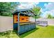 Stylish backyard bar with wood accents, overhead lighting, and built-in shelving and outlets at 12215 Blue Pacific Dr, Riverview, FL 33579