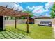 Beautiful backyard featuring green turf, a wooden pergola, and a custom bar and lounge area at 12215 Blue Pacific Dr, Riverview, FL 33579