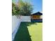 The fenced backyard features maintenance-free artificial turf and a flowering tree along the fence line at 12215 Blue Pacific Dr, Riverview, FL 33579