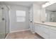 Bathroom boasts a shower with glass door, neutral tile floor, and double vanity at 12215 Blue Pacific Dr, Riverview, FL 33579