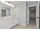 Bathroom featuring double sinks, white cabinets, and a view to the bedroom at 12215 Blue Pacific Dr, Riverview, FL 33579