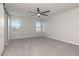 Bedroom features neutral carpet, fan, and natural light from two windows at 12215 Blue Pacific Dr, Riverview, FL 33579