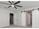 Neutral bedroom offers a ceiling fan and closet with sliding barn doors at 12215 Blue Pacific Dr, Riverview, FL 33579