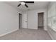 Spacious bedroom features neutral carpet, a ceiling fan, and multiple doorways at 12215 Blue Pacific Dr, Riverview, FL 33579