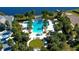 Stunning aerial view of the community pool surrounded by lush landscaping and palm trees at 12215 Blue Pacific Dr, Riverview, FL 33579