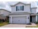 Beautiful two-story home with gray exterior, a two-car garage, and landscaped front yard for curb appeal at 12215 Blue Pacific Dr, Riverview, FL 33579