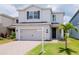 Beautiful two-story home with gray exterior, a two-car garage, and well-maintained landscaping at 12215 Blue Pacific Dr, Riverview, FL 33579