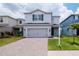 Two-story home with a gray exterior, two-car garage, landscaping and well-maintained lawn at 12215 Blue Pacific Dr, Riverview, FL 33579