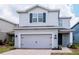 Charming two-story home featuring a gray exterior with a brick driveway and a convenient two-car garage at 12215 Blue Pacific Dr, Riverview, FL 33579