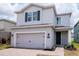Stunning two-story home with a gray exterior, two-car garage, and a beautifully landscaped yard at 12215 Blue Pacific Dr, Riverview, FL 33579