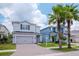 Two-story home featuring a driveway of pavers, a two-car garage, and professional landscaping at 12215 Blue Pacific Dr, Riverview, FL 33579
