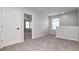 Upstairs hallway with gray walls, neutral carpet, white door and an open entrance at 12215 Blue Pacific Dr, Riverview, FL 33579