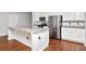 Modern kitchen featuring stainless steel appliances, granite countertops, white cabinets and wood flooring at 12215 Blue Pacific Dr, Riverview, FL 33579