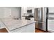 Modern kitchen island with stainless fridge, microwave, and granite countertops at 12215 Blue Pacific Dr, Riverview, FL 33579