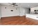 Open-concept living room featuring hardwood floors, white brick accent wall, and view into the kitchen at 12215 Blue Pacific Dr, Riverview, FL 33579