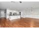 Spacious living room with hardwood floors, white cabinets, a center island, and a modern lighting fixture at 12215 Blue Pacific Dr, Riverview, FL 33579