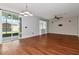 Open living room with hardwood floors, ceiling fan, sliding glass doors, and brick accent wall at 12215 Blue Pacific Dr, Riverview, FL 33579