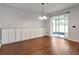 Spacious living room featuring hardwood floors, modern lighting, built-in cabinets, and sliding glass doors at 12215 Blue Pacific Dr, Riverview, FL 33579