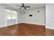 Brightly lit living room featuring hardwood floors, a ceiling fan, and a white brick accent wall at 12215 Blue Pacific Dr, Riverview, FL 33579