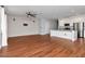 Bright living room with hardwood floors, brick accent wall, ceiling fan, and modern kitchen at 12215 Blue Pacific Dr, Riverview, FL 33579