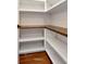 Walk-in pantry with custom wood shelving and white brick walls for storing food and supplies at 12215 Blue Pacific Dr, Riverview, FL 33579