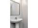 Modern powder room featuring a pedestal sink with chrome faucet and rectangular mirror at 12215 Blue Pacific Dr, Riverview, FL 33579