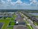 This aerial view displays the single-Gathering home and its location on a quiet neighborhood street near a lake at 12931 Twin Bridges Dr, Riverview, FL 33579
