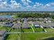 Aerial view of a home with a fenced backyard, part of a community near a scenic lake at 12931 Twin Bridges Dr, Riverview, FL 33579
