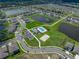Community aerial view showcases pool, clubhouse, volleyball court and surrounding homes and ponds at 12931 Twin Bridges Dr, Riverview, FL 33579