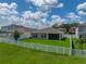 Aerial view of backyard with white fence, green lawn, and view of the home's rear exterior at 12931 Twin Bridges Dr, Riverview, FL 33579