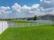 A lush backyard showcases a sprawling green lawn and the tranquility of a waterfront view at 12931 Twin Bridges Dr, Riverview, FL 33579