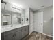 Bathroom with a double vanity, quartz countertop, wood-look flooring, and modern lighting at 12931 Twin Bridges Dr, Riverview, FL 33579