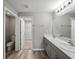 Bathroom with a double vanity, wood look flooring and a view into the adjacent water closet and walk in closet at 12931 Twin Bridges Dr, Riverview, FL 33579