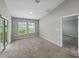 Bright bedroom with neutral carpet, large windows, and sliding glass door at 12931 Twin Bridges Dr, Riverview, FL 33579