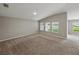 A bright bedroom featuring carpet, three windows, and neutral color palette at 12931 Twin Bridges Dr, Riverview, FL 33579
