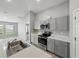 Gray cabinets, stainless steel appliances, and a view to the living area in this modern kitchen at 12931 Twin Bridges Dr, Riverview, FL 33579