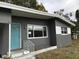 Beautiful home featuring a blue front door, clean landscaping, and updated exterior paint at 1317 Tyrone N Blvd, St Petersburg, FL 33710