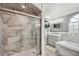 Modern bathroom features a glass enclosed shower, soaking tub, and vanity with bright lighting and gray toned tile at 14096 Pullman Dr, Spring Hill, FL 34609