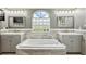 Bright bathroom with double vanities, white soaking tub, tile accents, and a unique glass block window at 14096 Pullman Dr, Spring Hill, FL 34609