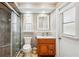 Neutral bathroom with a glass enclosed shower, wood cabinet, and vanity with sink with window at 14096 Pullman Dr, Spring Hill, FL 34609