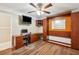 Bedroom with hardwood floors includes a ceiling fan, built-in desk area, and wall-mounted TV at 14096 Pullman Dr, Spring Hill, FL 34609