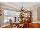 Elegant dining room with a wooden table set, chandelier lighting and lots of natural light at 14096 Pullman Dr, Spring Hill, FL 34609