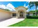 Welcoming facade with an arched portico, columns and a well-manicured lawn at 14096 Pullman Dr, Spring Hill, FL 34609