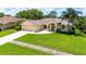 Spacious lawn with driveway leading to a two-car garage and front entrance at 14096 Pullman Dr, Spring Hill, FL 34609