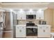 Modern kitchen with stainless steel appliances, white cabinets, and tile backsplash at 14096 Pullman Dr, Spring Hill, FL 34609